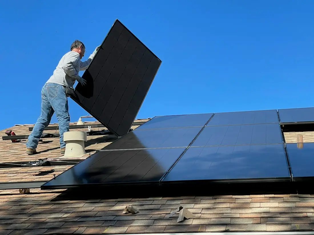 Instalador colocando una placa solar en un tejado